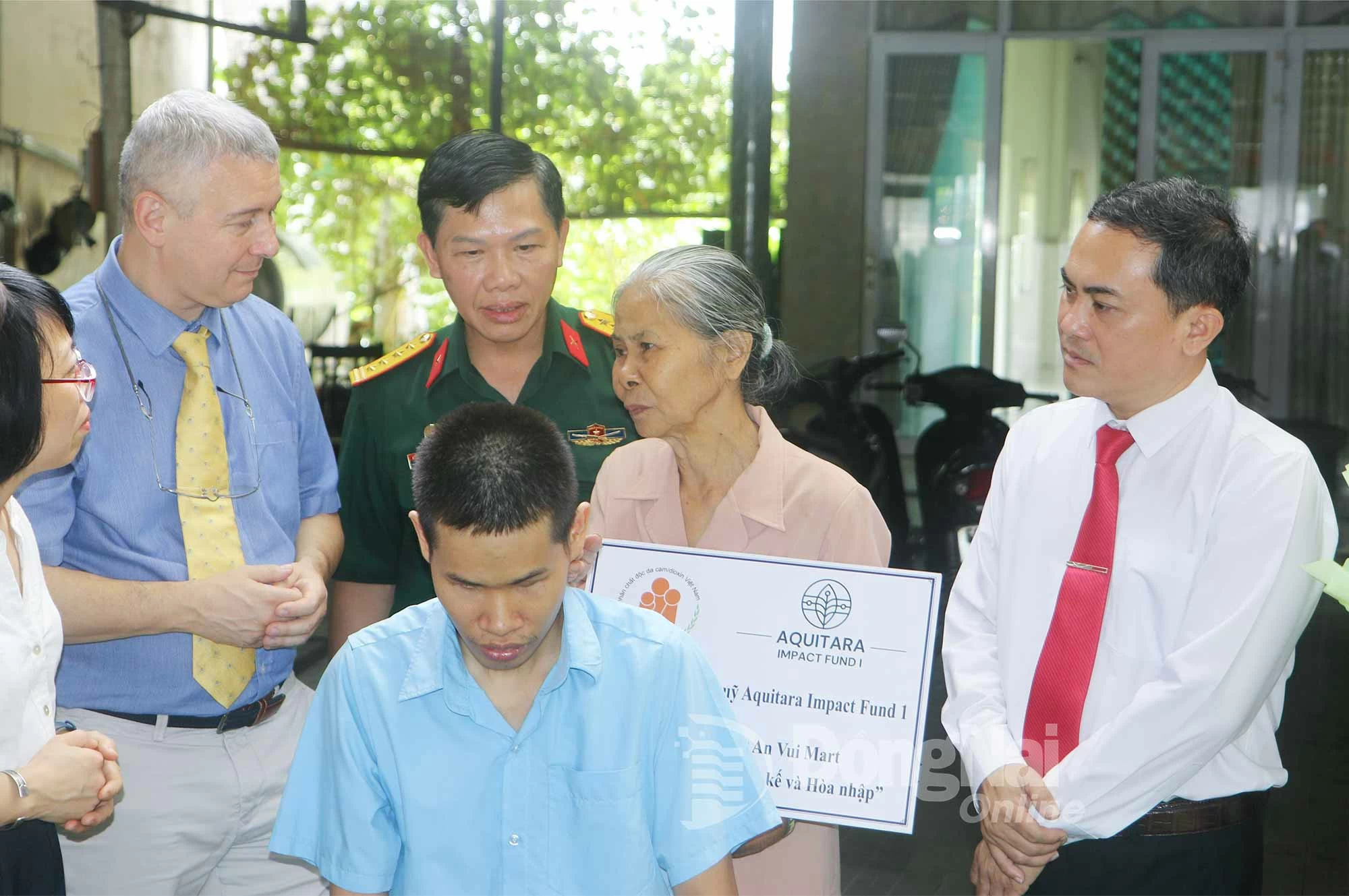 Vice Chairman Le Truong Son and Ambassador Karl Van Den Bossche listen to life story of Dang Van Nai’s family, AO victim in Long Binh ward.