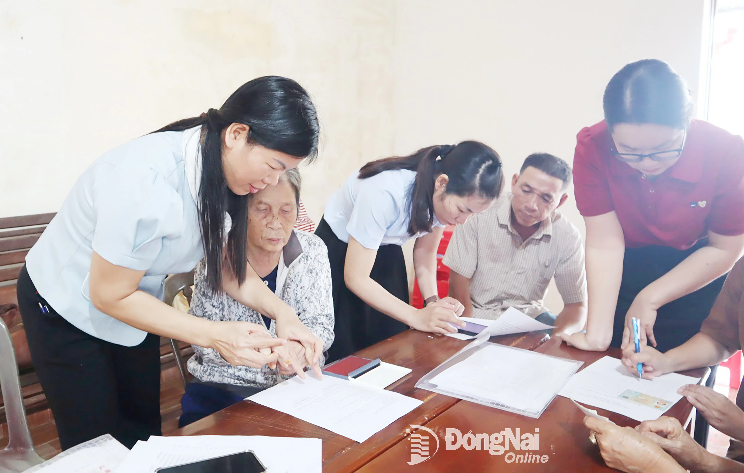 Tổ lưu động phường Bình Phước hỗ trợ người cao tuổi khu phố Suối Đá hoàn tất hồ sơ hưởng trợ cấp hưu trí xã hội. Ảnh: Nhã Trâm