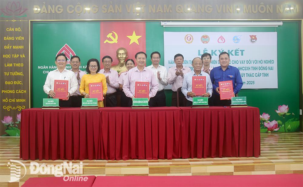 Lãnh đạo các đơn vị liên quan ký kết văn bản liên tịch về việc thực hiện ủy thác cho vay đối với hộ nghèo và các đối tượng chính sách khác. Ảnh: Hải Quân