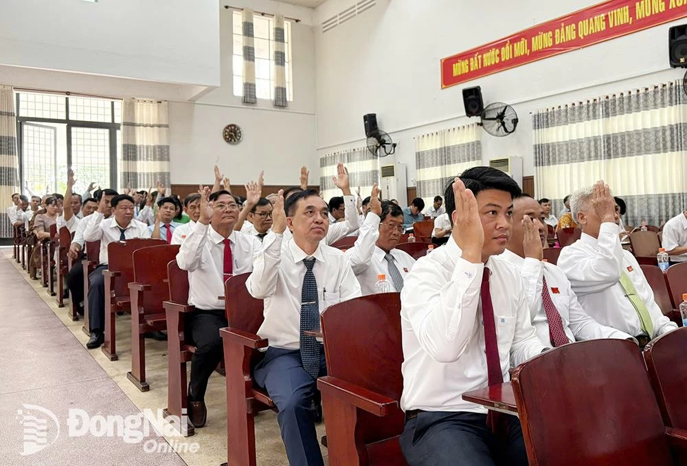 Các đại biểu HĐND xã Định Quán biểu quyết thông qua nghị quyết tại kỳ họp. Ảnh: Đan Nhi