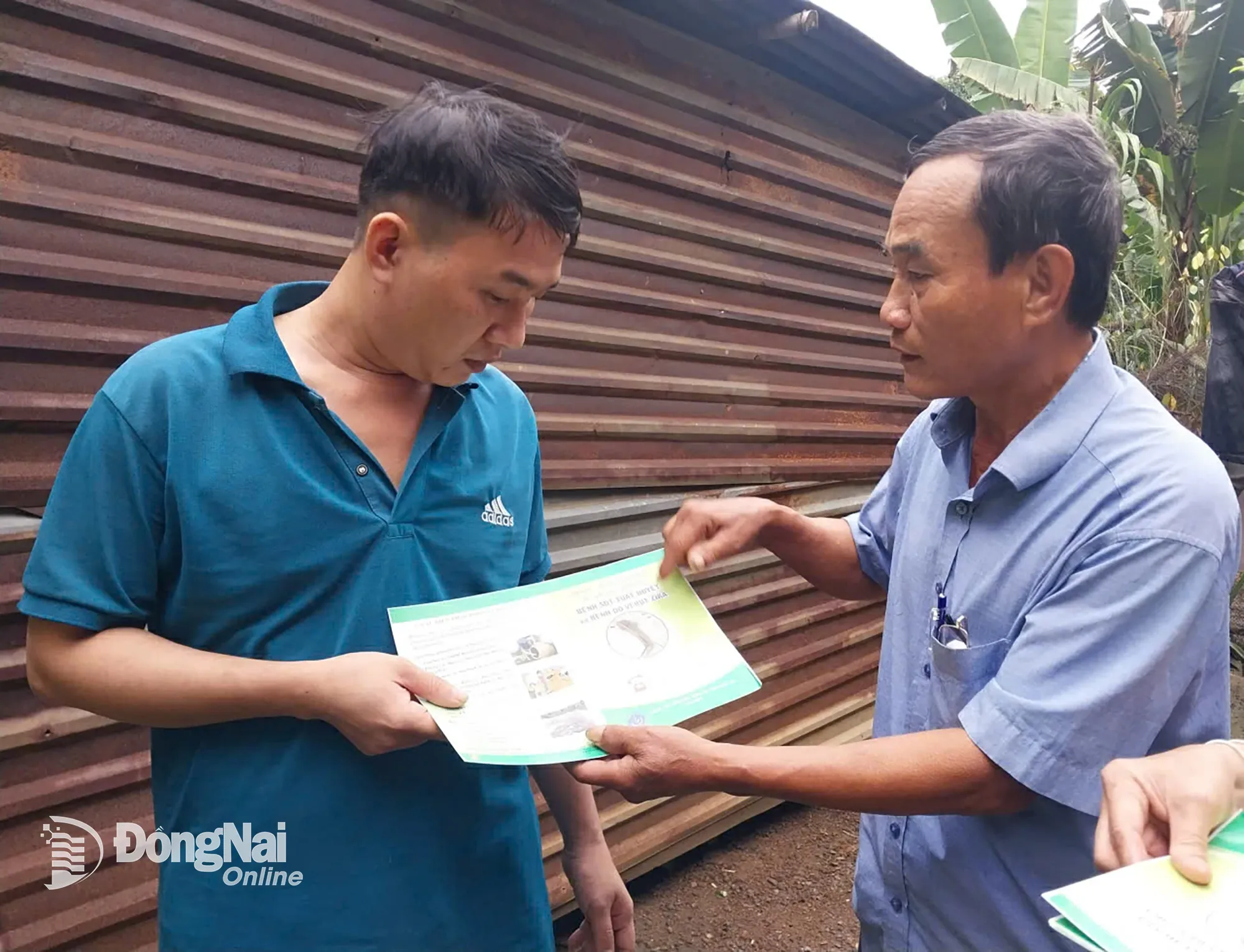 Cán bộ ấp Hưng Nghĩa đến từng hộ gia đình để hướng dẫn các biện pháp phòng, chống sốt xuất huyết và phát tờ rơi tuyên truyền. Ảnh: Nhật Quang