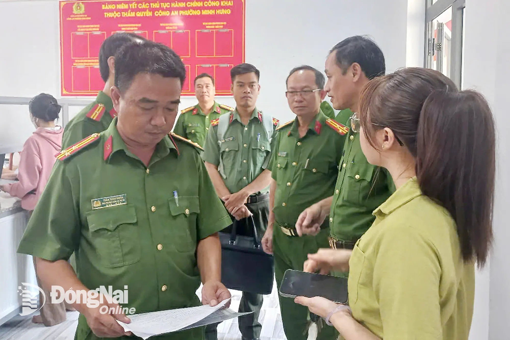 Thượng tá Trần Tuấn Nghĩa, Trưởng Công an phường Minh Hưng trao đổi với người dân tại bộ phận một cửa công an phường. Ảnh: T.D