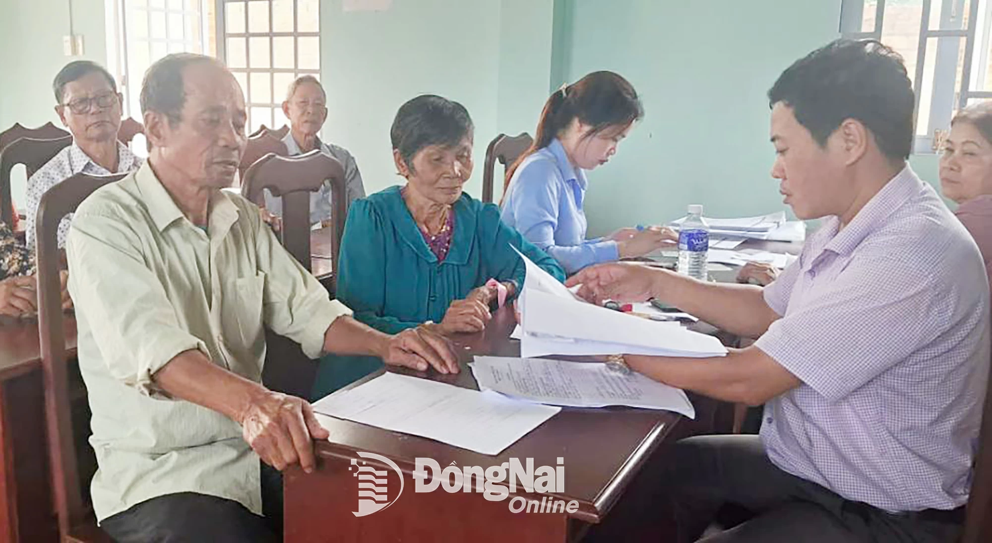 Cán bộ Trung tâm Hành chính công, Phòng Văn hóa - Thông tin và đoàn viên thanh niên hỗ trợ người dân làm thủ tục, giấy tờ tại nhà văn hóa ấp.