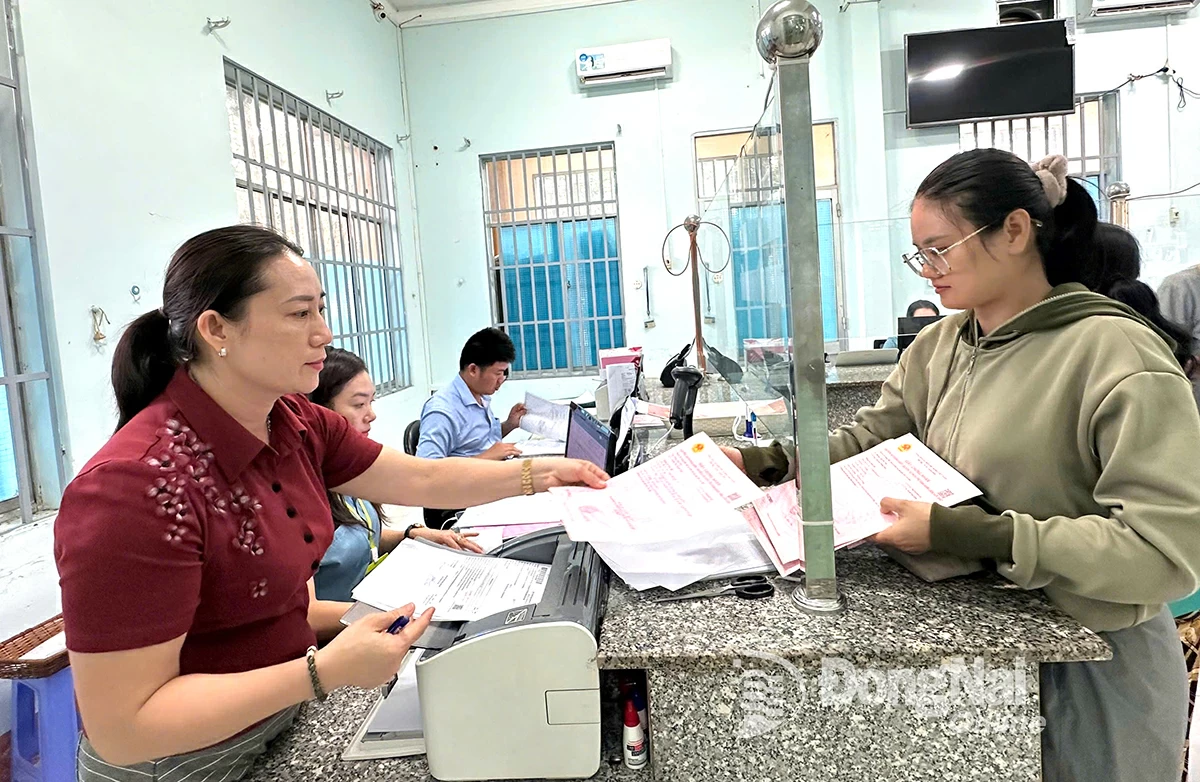 Phó giám đốc Trung tâm Phục vụ hành chính công xã Thiện Hưng Hồ Thị Đào trao giấy chứng nhận quyền sử dụng đất cho người dân. Ảnh: Như Tình
