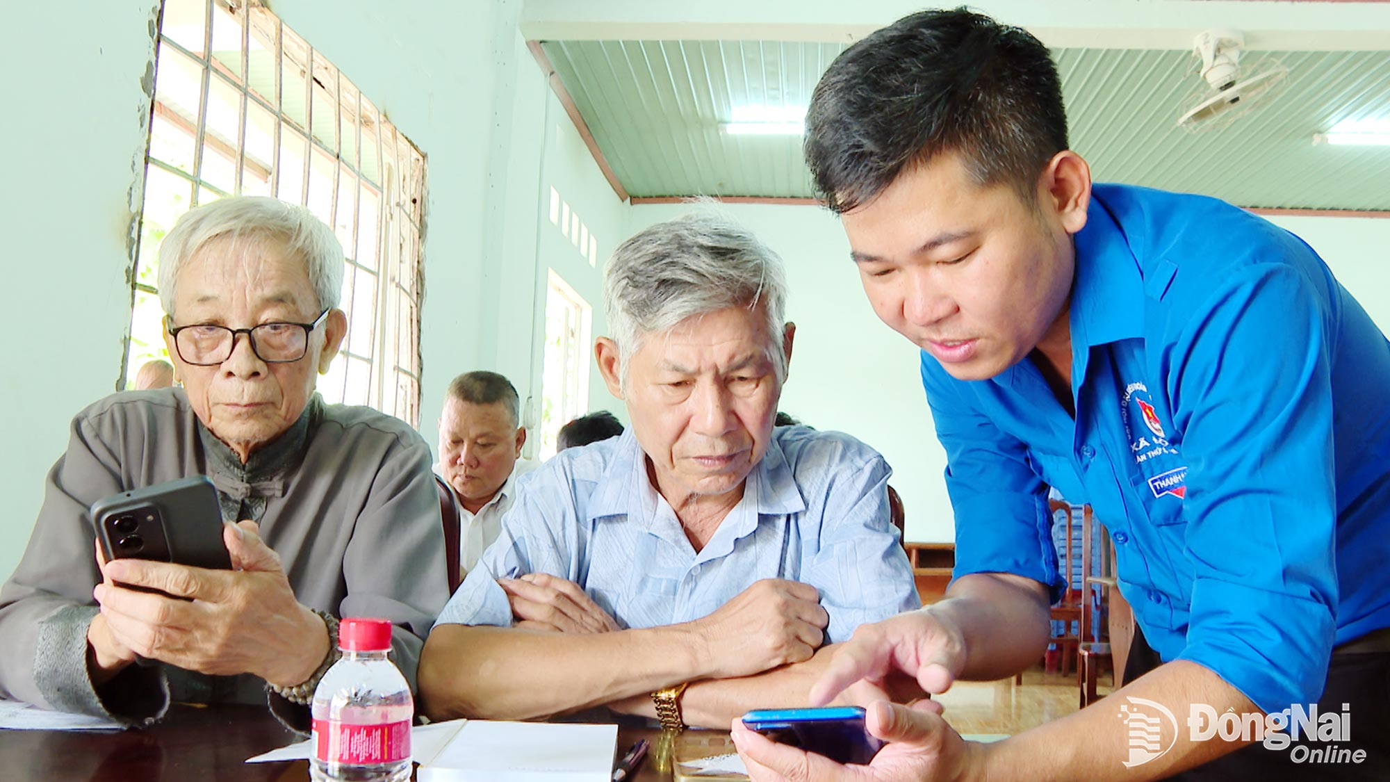 Youth Union members and young people of Dong Phu Ward visit Party cells to guide elderly Party members in using the Electronic Party Member Handbook application. Photo: XT

