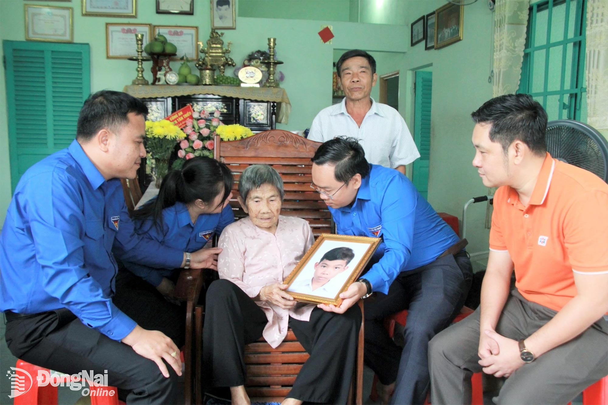 Thành ủy viên, Phó Chủ tịch Ủy ban MTTQ Việt Nam thành phố, Bí thư Thành đoàn Nguyễn Minh Kiên (thứ 2 từ phải sang) trao tận tay bức ảnh sau phục dựng của liệt sĩ Nguyễn Văn Dậy là con trai Mẹ Việt Nam anh hùng Hồ Thị Vàng (phường Tân Triều). Ảnh: Nga Sơn