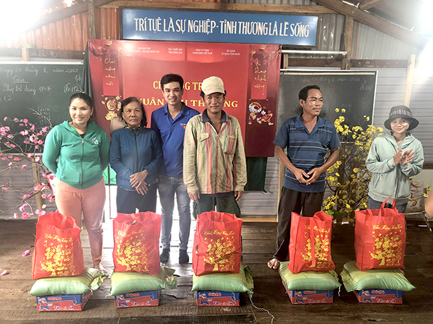 Anh Nguyễn Lê Hải Sơn (thứ 3 từ trái qua) tặng quà cho người dân có hoàn cảnh khó khăn ở lòng hồ Trị An (H.Vĩnh Cửu)