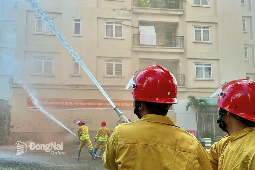 Lực lượng chữa cháy tại chỗ xử lý đám cháy giả định tại khối nhà A5, chung cư Nguyễn Văn Trỗi (Ảnh: Đăng Tùng)