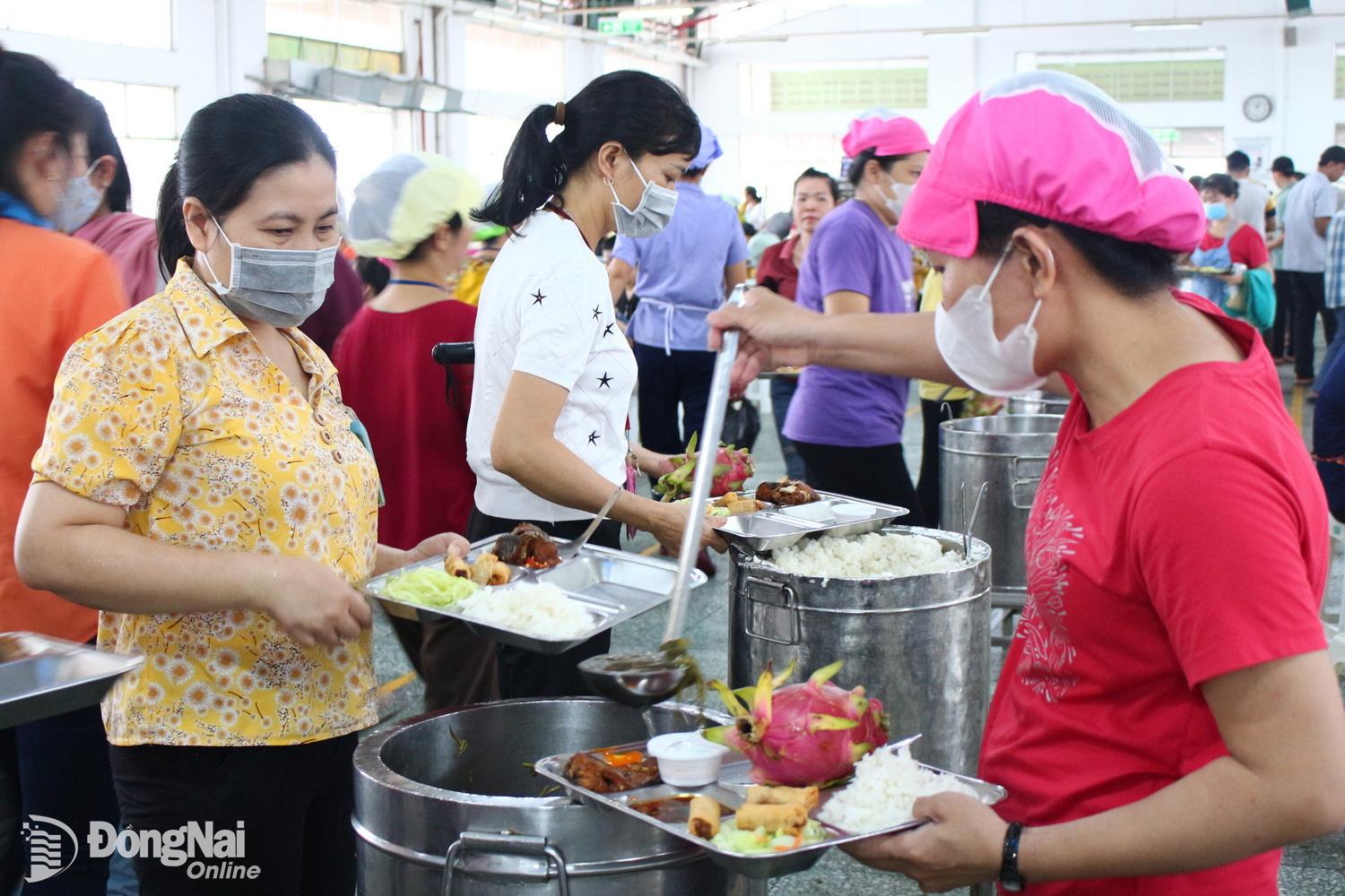 2-	Công nhân Công ty TNHH Pouchen Việt Nam phấn khởi với bữa cơm giữa ca. ảnh: N.Hòa