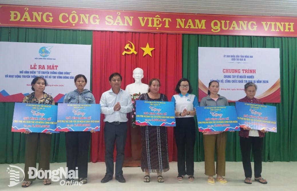 Các đại biểu trao bảng tượng trưng hỗ trợ kinh phí thực hiện mô hình sinh kế cho hội viên, phụ nữ dân tộc có hoàn cảnh khó khăn. Ảnh: ĐVCC