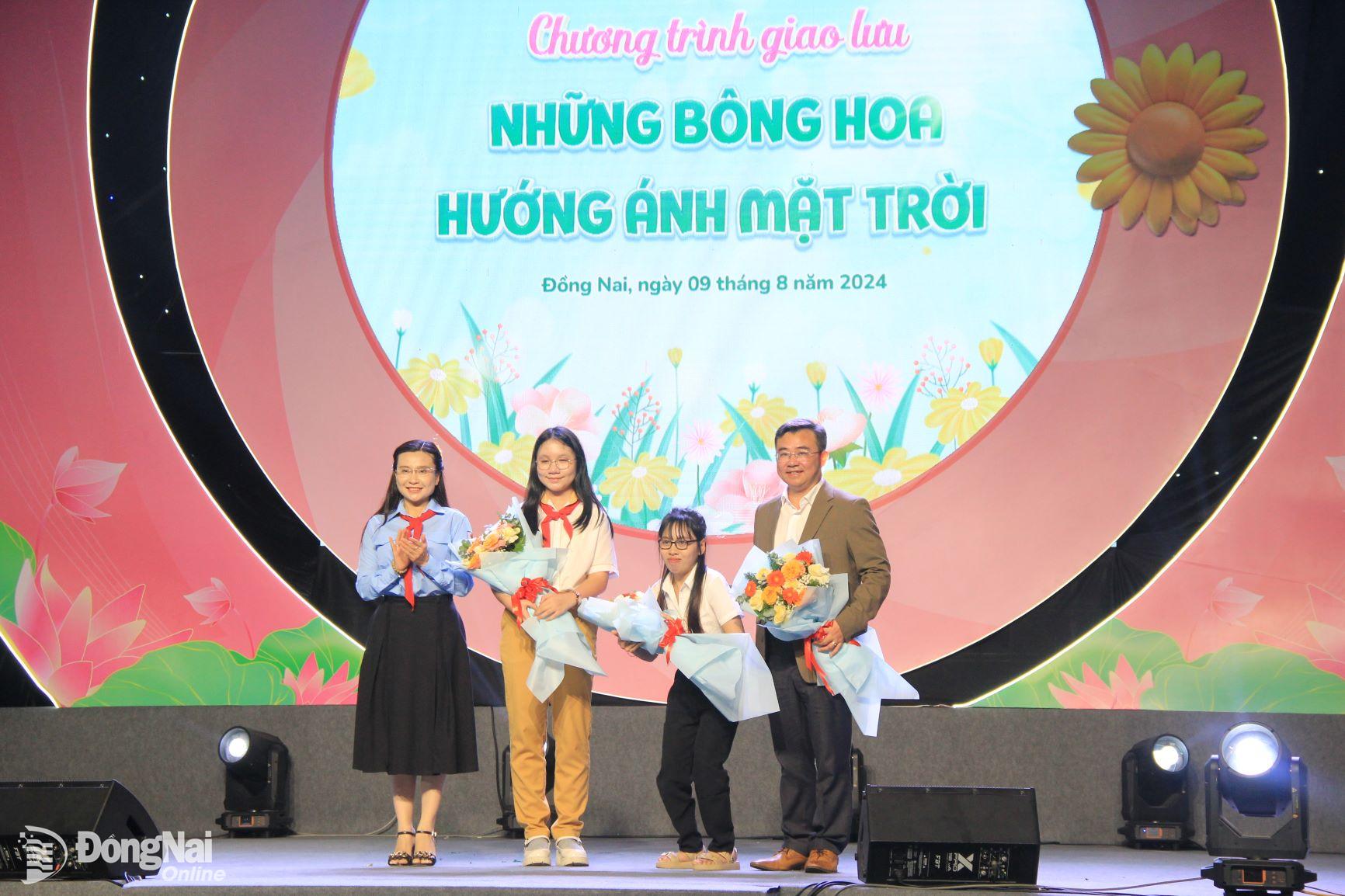 Bí thư Trung ương Đoàn, Chủ tịch Hội đồng Đội Trung ương Nguyễn Phạm Duy Trang tặng hoa các vị khách mời tham gia chương trình giao lưu Những bông hoa hướng ánh mặt trời. Ảnh: Nga Sơn