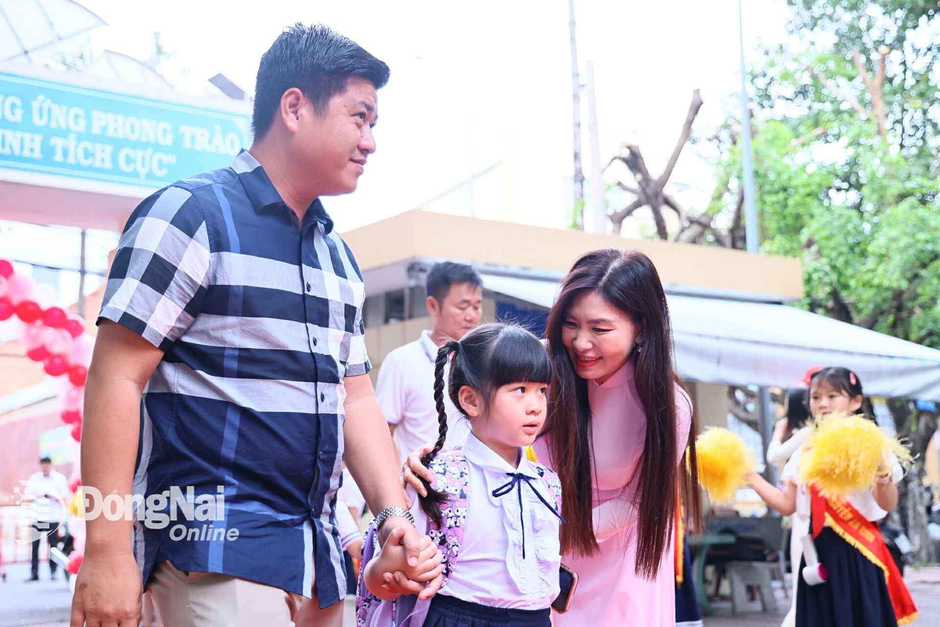 Students are welcomed by teachers at the entrance gate of the school on the first day of grade 1 at Nguyen An Ninh Primary School (Tam Hiep ward)