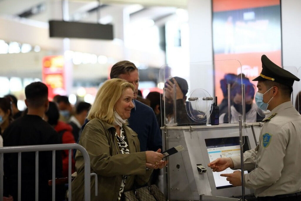 An aviation security official checks passenger information before security screening__Photo: VNA
