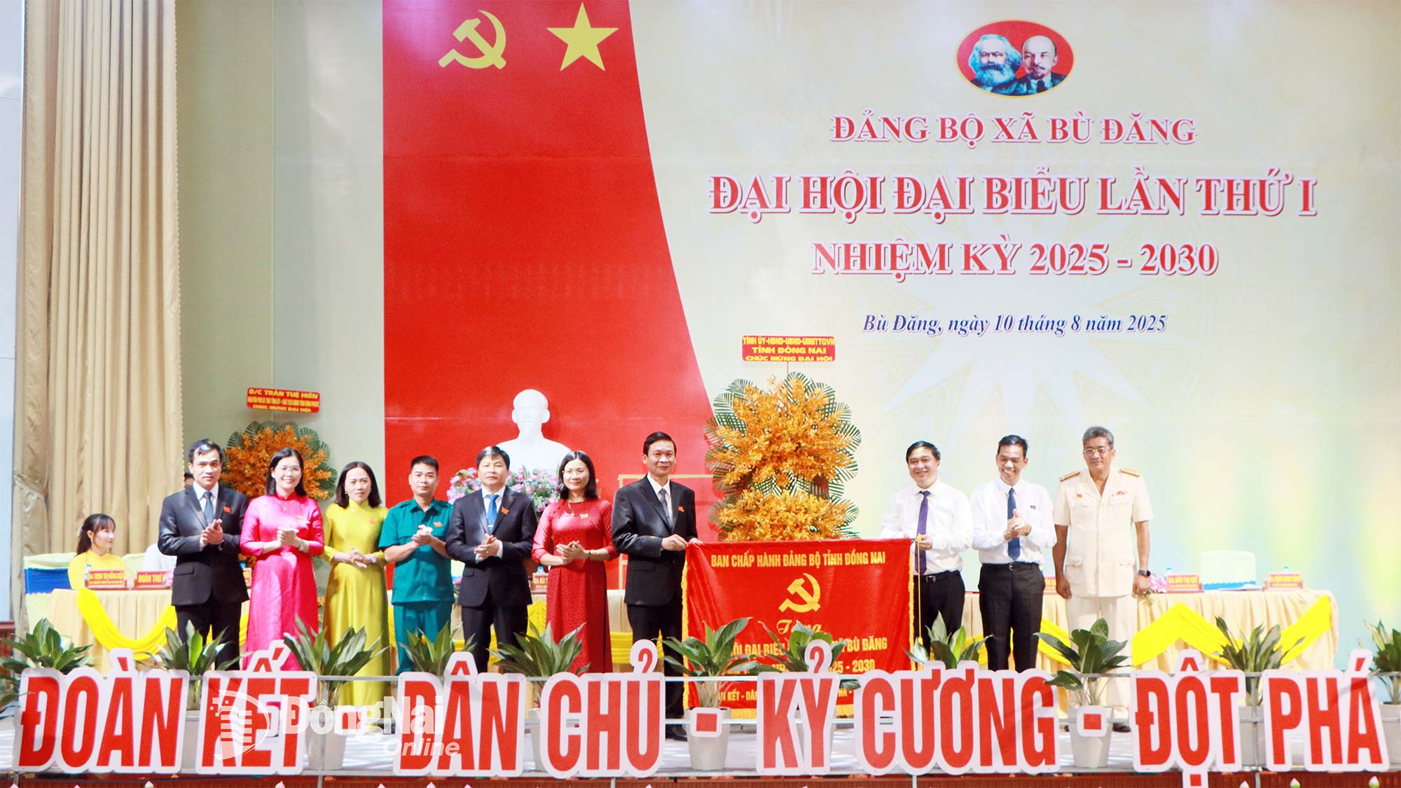 Tran Trung Nhan, Member of the Dong Nai Provincial Party Committee’s Standing Board and Chairman of the Provincial Party Committee’s Inspection Commission, and Ho Van Ha, Member of the Provincial Party Committee and Vice Chairman of the Dong Nai People’s Committee, present a flower basket from the Dong Nai Party Committee, People’s Council, People’s Committee, and Fatherland Front Committee, along with a banner from the Provincial Party Committee’s Executive Board to the congress. (Photo: Nhu Nam)