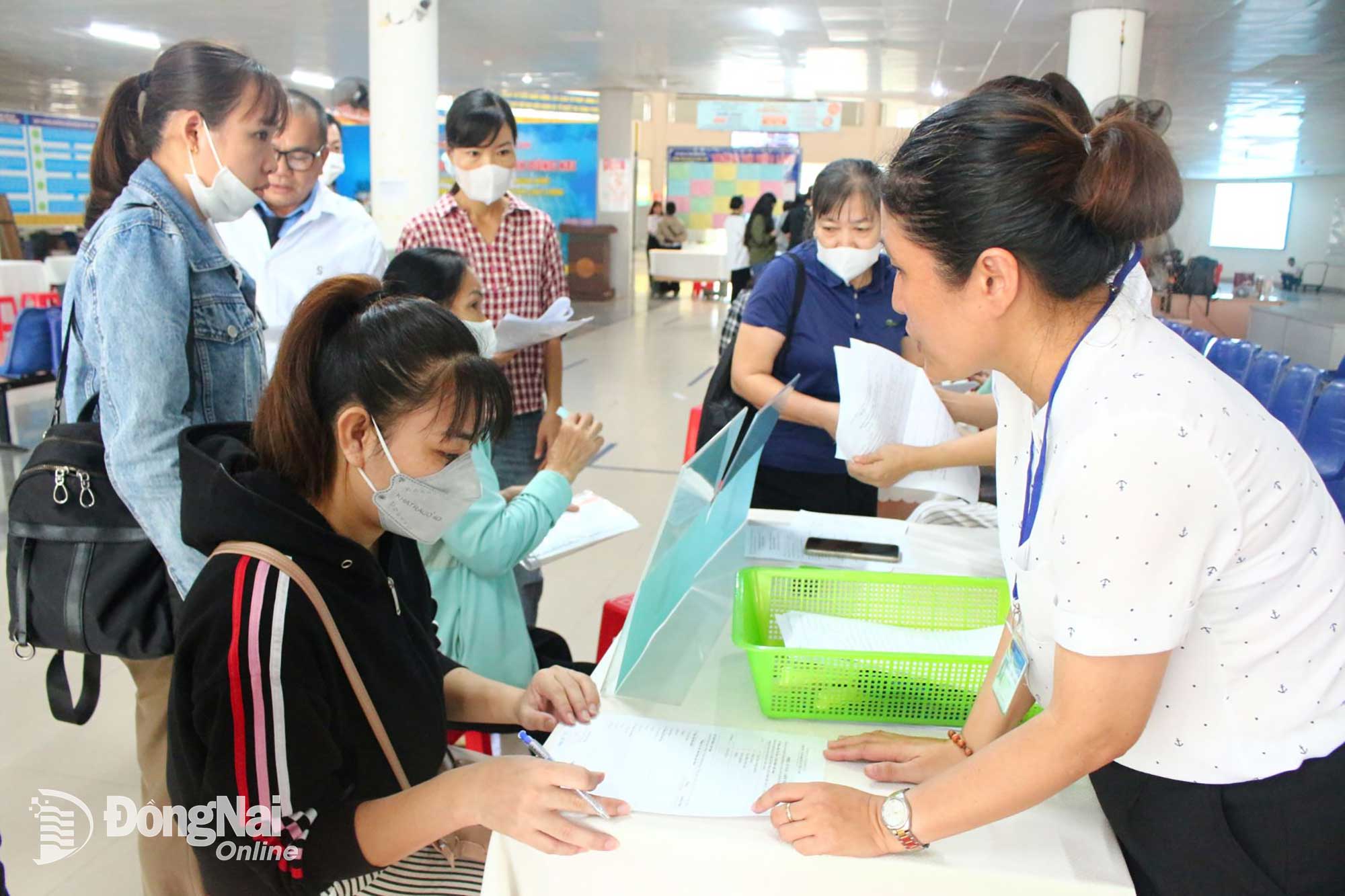 Staff at the Dong Nai Provincial Employment Service Center guide workers to fill in information for job searching and vocational training at the Job Fair. Photo: N.Hoa