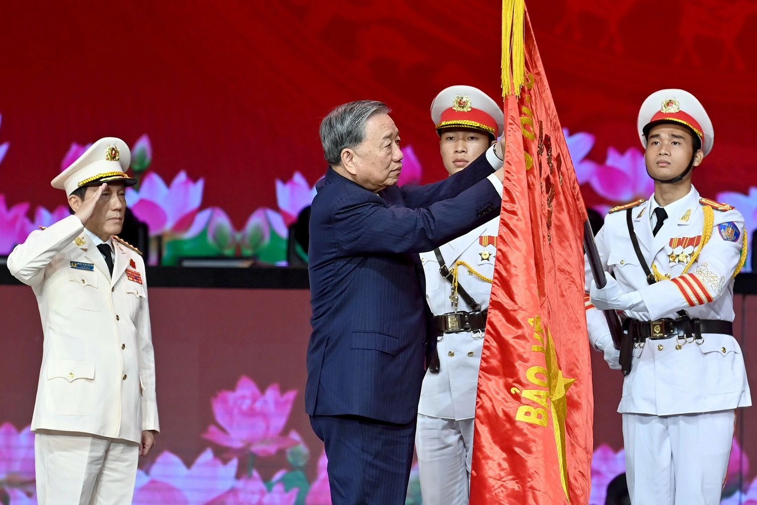 Tổng Bí thư Tô Lâm gắn Huân chương Sao Vàng lên lá cờ truyền thống của Lực lượng Công an nhân dân Việt Nam. (Ảnh ĐĂNG KHOA)