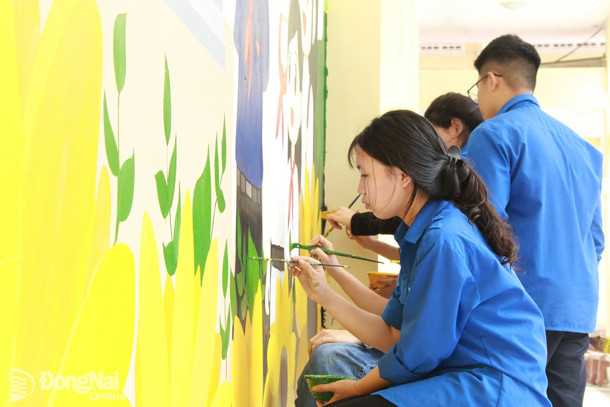 Đoàn viên, thanh niên Trường cao đẳng Mỹ thuật trang trí Đồng Nai thực hiện công trình thanh niên chào mừng đại hội Đảng các cấp tại Trường THCS Trần Hưng Đạo (phường Trấn Biên). Ảnh: NGUYỄN TUYẾT