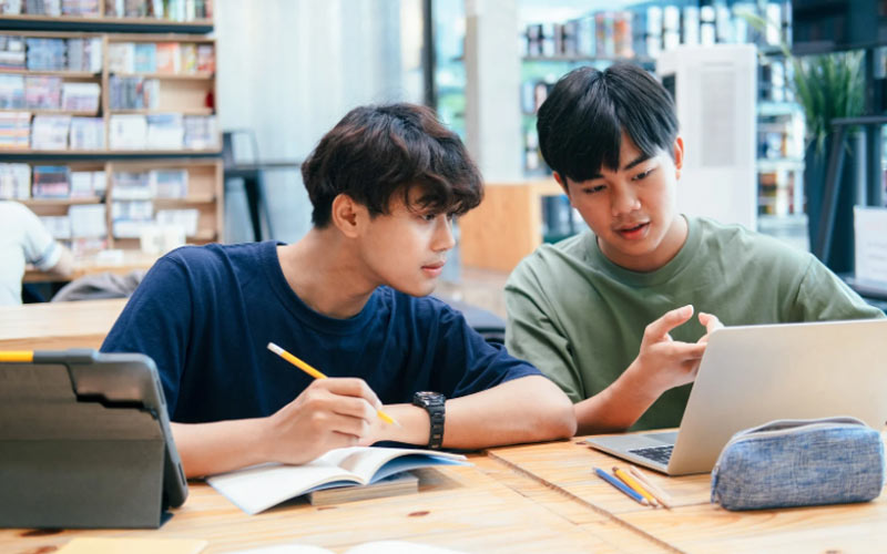 Học sinh dùng điện thoại hỏi đáp AI tại thư viện.