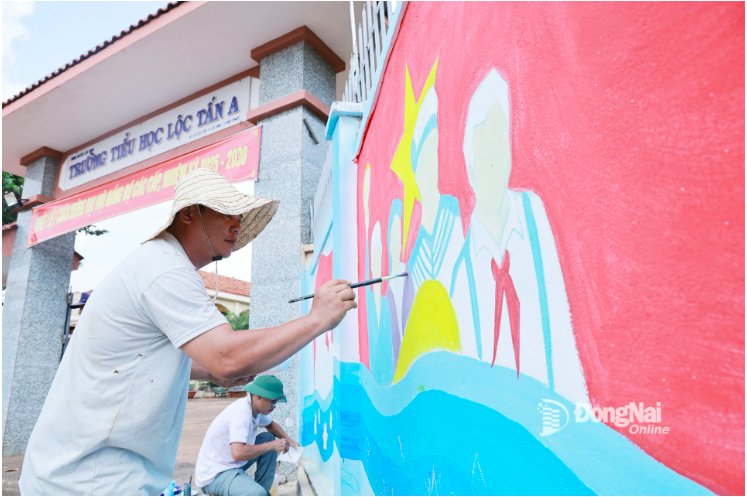 Teachers of Loc Tan A Primary School diligently complete a mural on the theme of the homeland in front of the school gate to welcome students for the new school year. Photo: Cong Nghia

