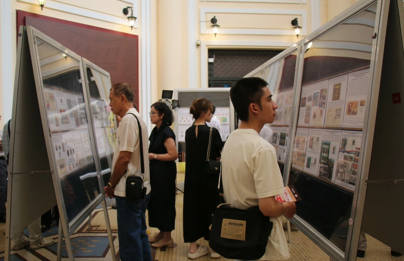 Delegates look at stamp collections at the exhibition. (Photo: VNA)