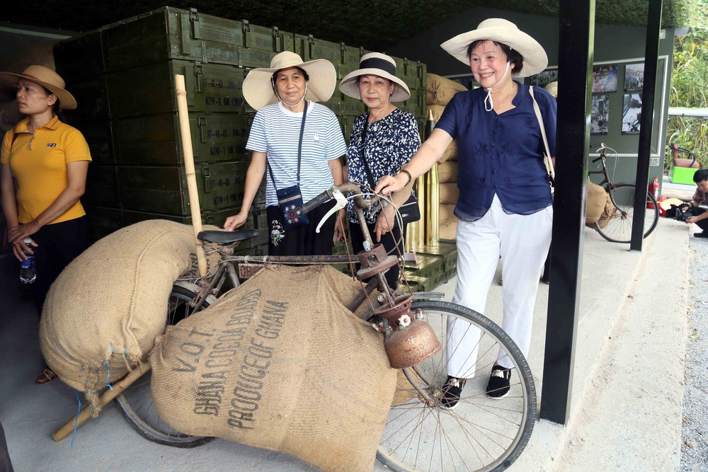 Du khách tham quan xe thồ chở hàng thi công mở Đường 20 Quyết Thắng. Ảnh: Tá Chuyên - TTXVN