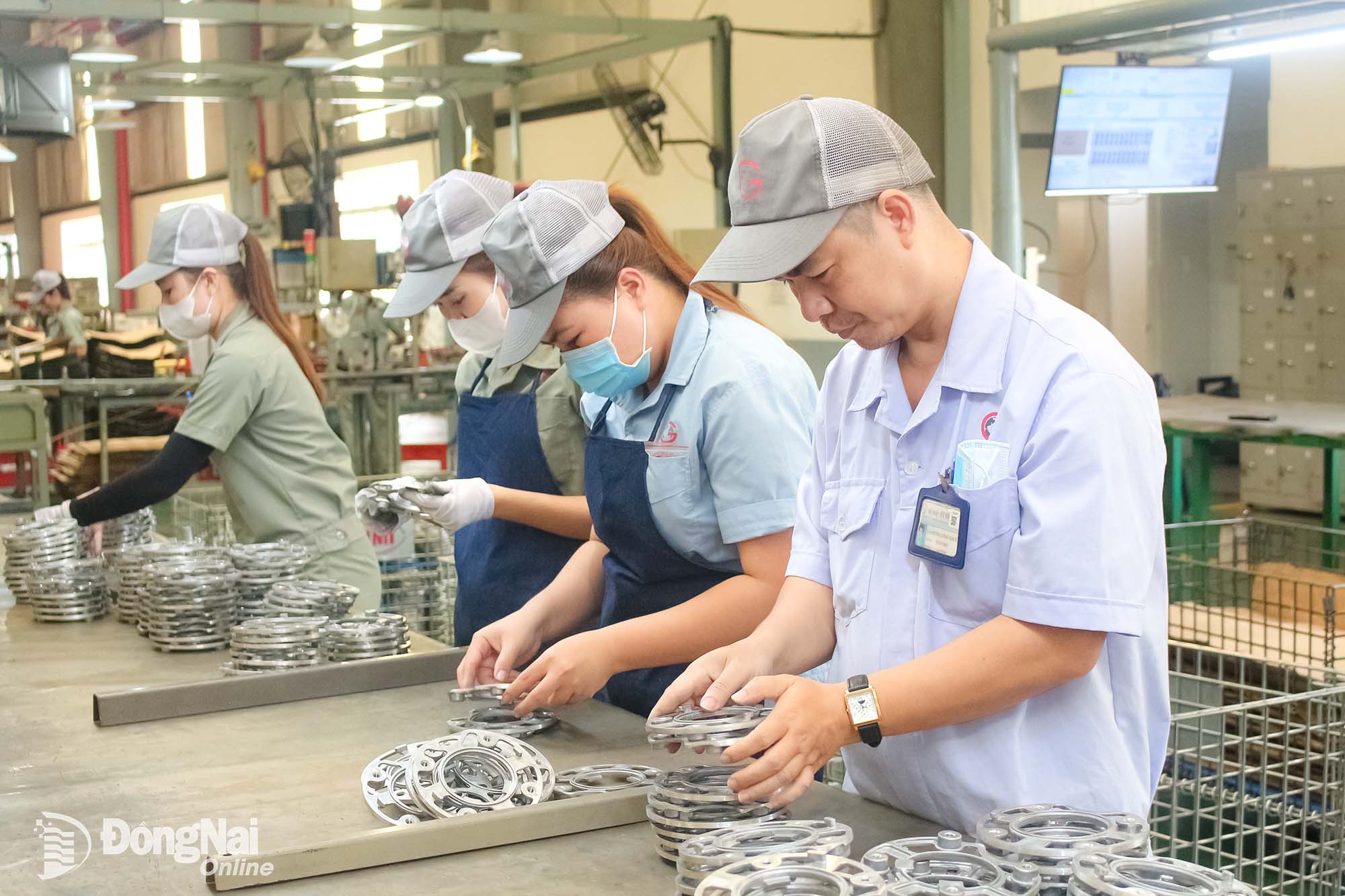 Anh Dương Công Khuê (bìa phải), đoàn viên Công đoàn Công ty Hữu hạn cơ khí động lực Toàn Cầu (phường Trảng Bom) hướng dẫn công nhân thao tác tại xưởng sản xuất.
