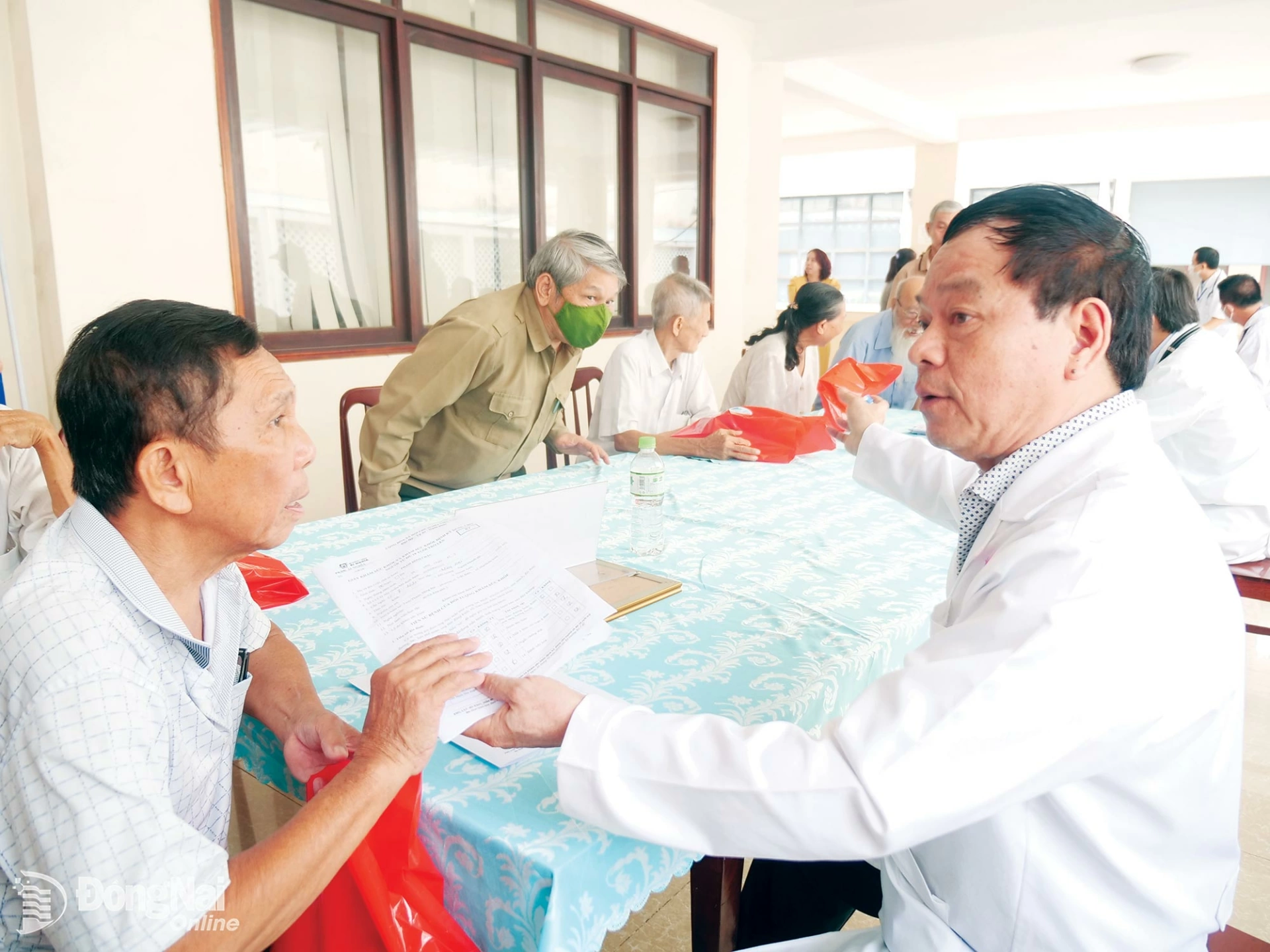 Dr. Hoang Nghia Dai, who holds a masters degree and serves as an advisor to the Ai Nghia Medical System, advises a resident on treatment options following a health screening. Photo: Hanh Dung