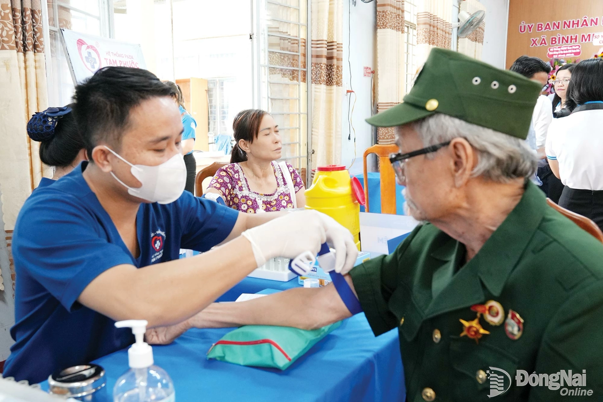 Medical staff take a blood sample from a veteran in Binh Minh commune for health screening tests. Photo: Bao Han