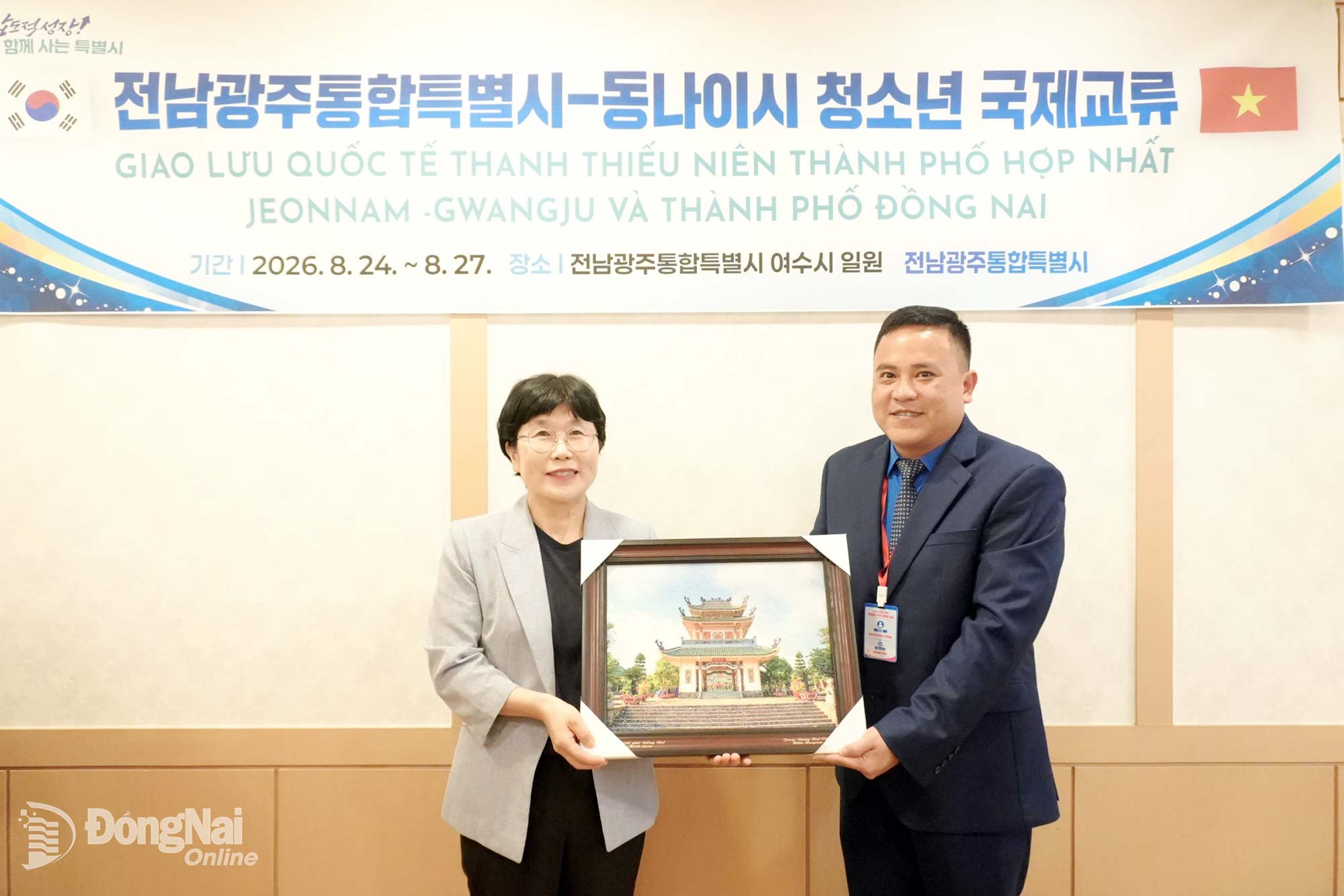 Nguyen Hieu Trung, Deputy Secretary of the City Youth Union, presents a painting of the Tran Bien Temple of Literature to a representative of Jeonnam-Gwangju City.