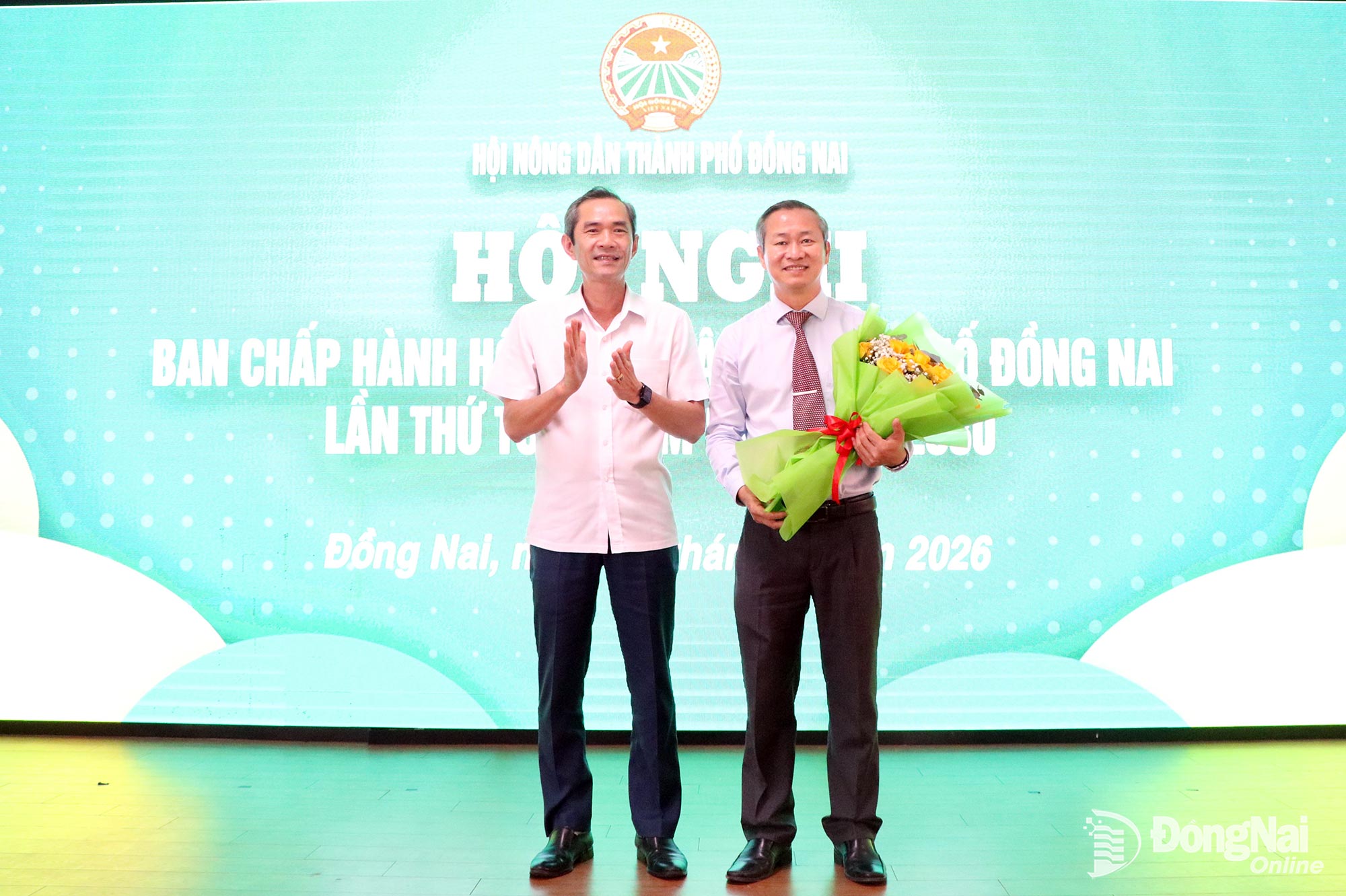 Phó Chủ tịch Ủy ban MTTQ Việt Nam thành phố Nguyễn Tất Độ tặng hoa chúc mừng tân Chủ tịch Hội Nông dân thành phố Cao Tiến Sỹ. Ảnh: Tố Tâm