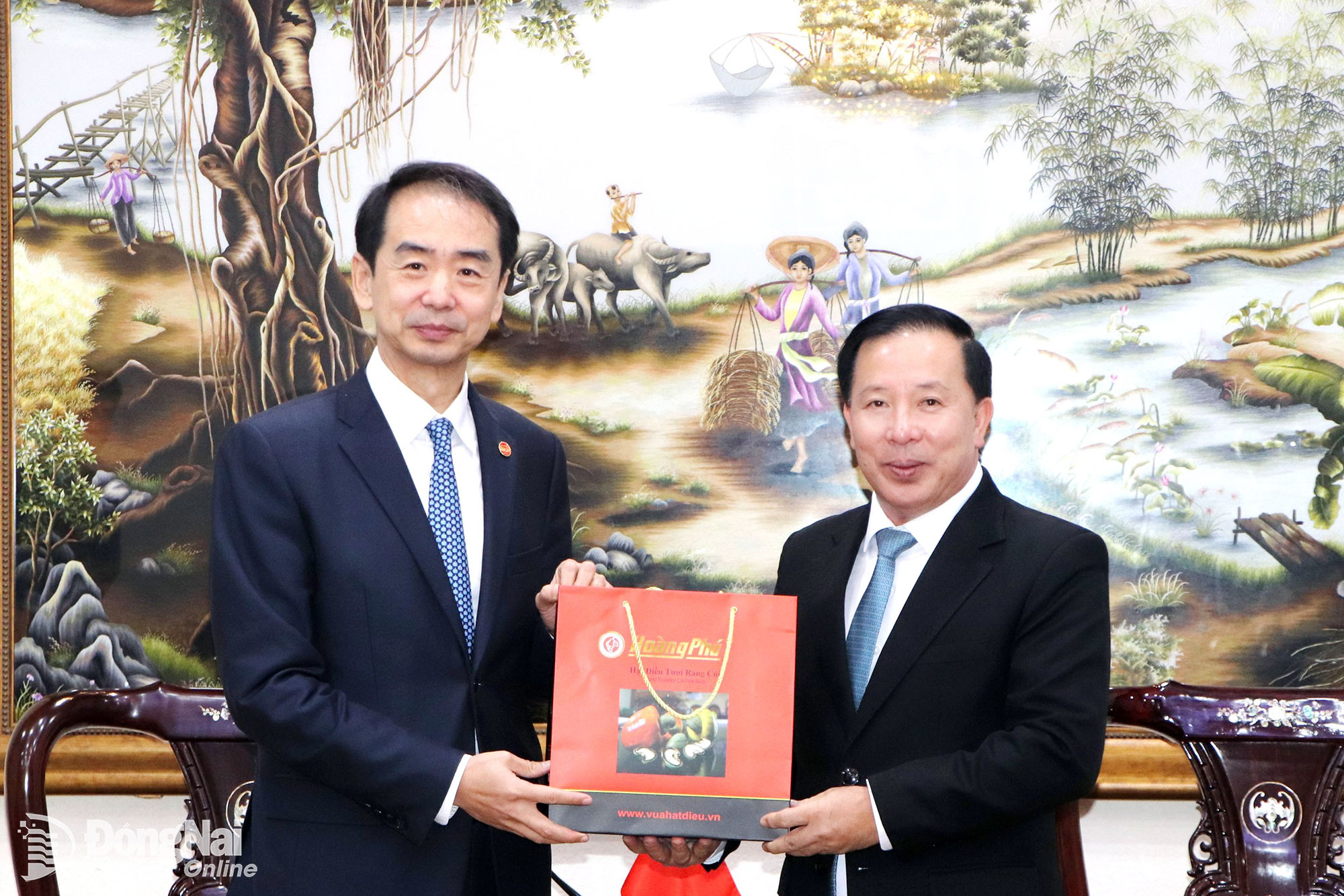 Deputy Secretary of the City Party Committee and Chairman of the City Peoples Committee Nguyen Van Ut presents Dong Nais specialty cashew nuts to the Chinese Ambassador to Vietnam. Photo: Ngoc Lien