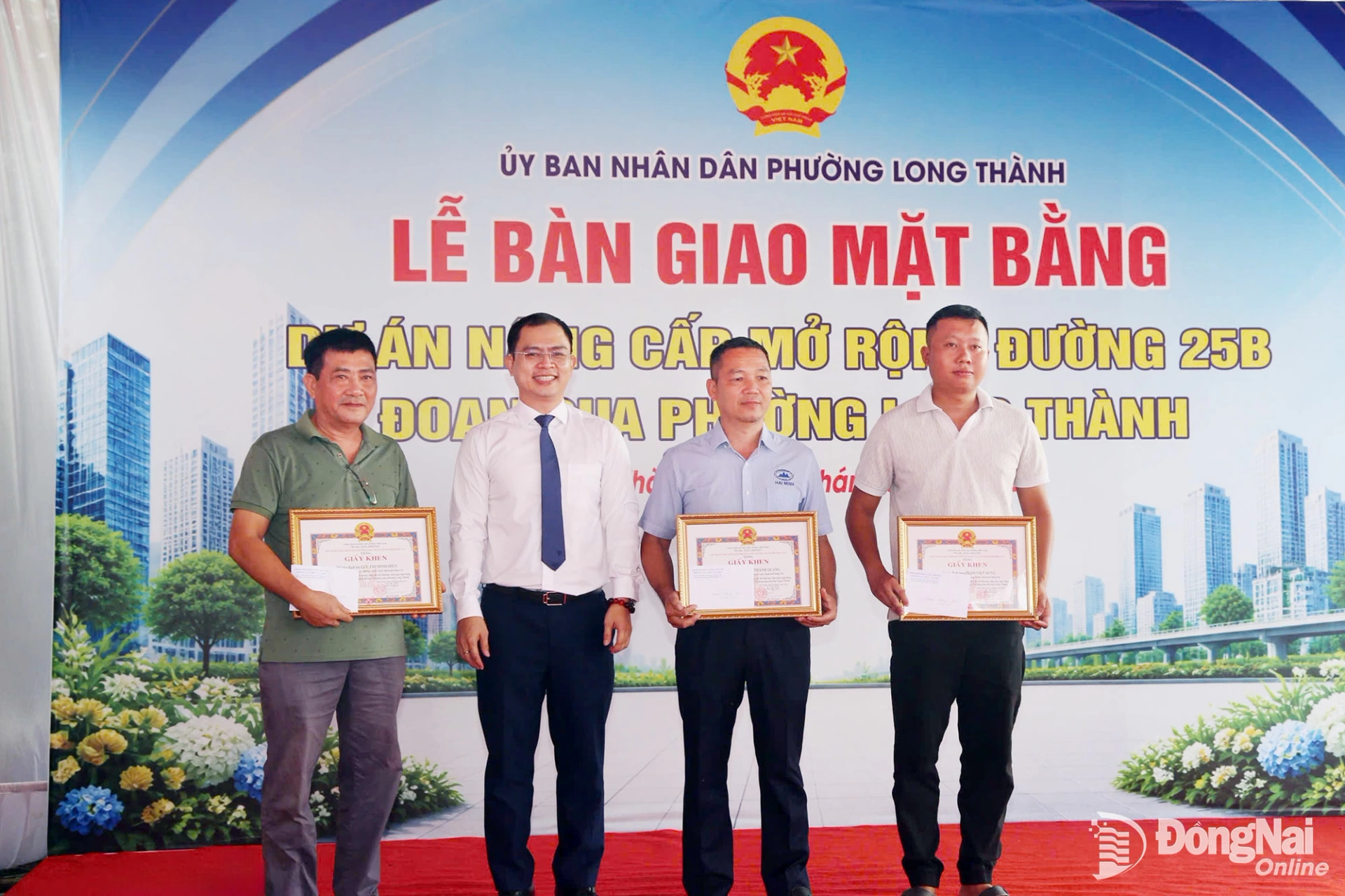 Chairman of the Long Thanh Ward Peoples Committee Le Hoang Son presents awards to collectives and individuals with outstanding achievements in compensation and site clearance for the project. Photo: Pham Tung

