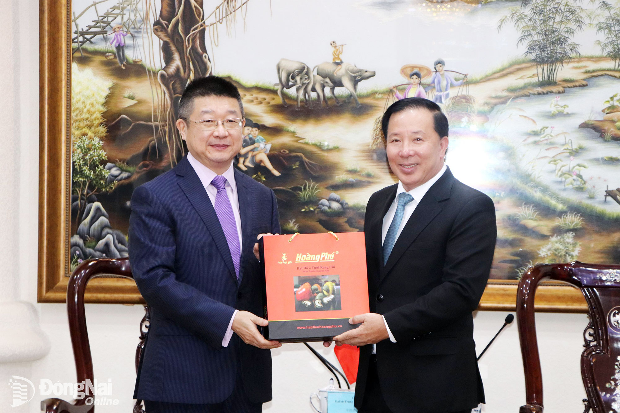 Deputy Secretary of the City Party Committee and Chairman of the City Peoples Committee Nguyen Van Ut presents Dong Nais specialty cashew nuts to Chinese Consul General in Ho Chi Minh City Tang Li. Photo: Ngoc Lien