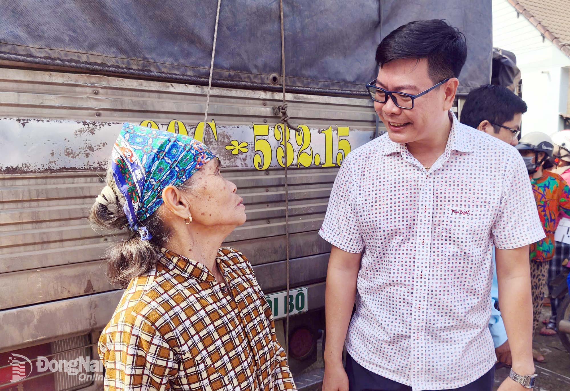Chủ tịch UBND xã Thanh Sơn Võ Văn Trung thăm hỏi, trò chuyện với người dân được trao sinh kế. Ảnh: Hà Nội

