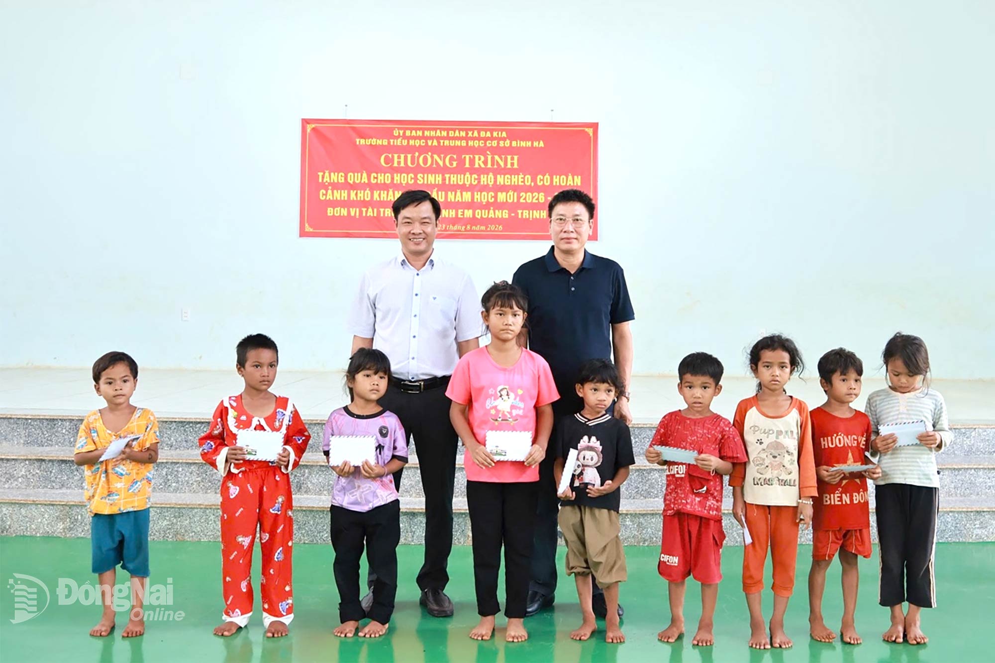 Phó Chủ tịch UBND xã Đa Kia Nguyễn Viết Thư (bìa trái) cùng đại diện nhóm thiện nguyện trao quà cho học sinh.

