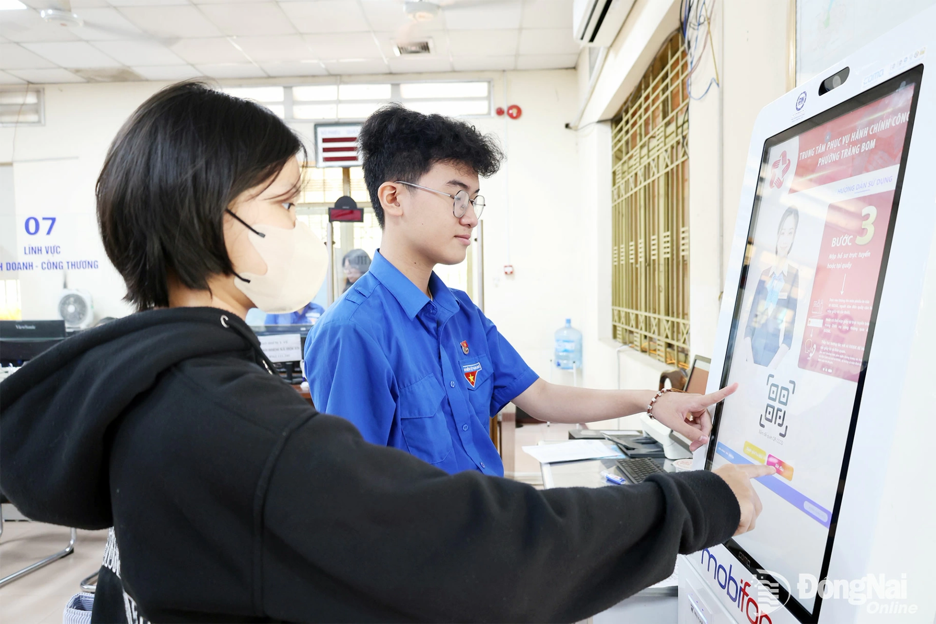 Residents receive guidance from youth volunteers on how to use a smart kiosk at the Trang Bom Ward Public Administration Service Center.