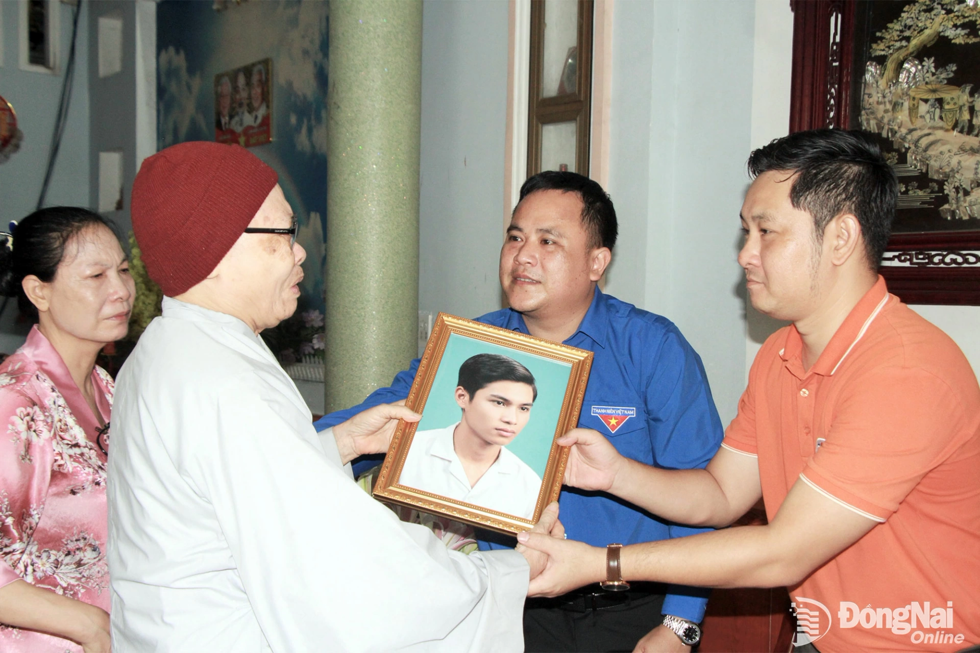 Đại diện Thành đoàn và Trường cao đẳng FPT Polytechnic tại Đồng Nai trao tặng ảnh phục dựng của liệt sĩ Nguyễn Vũ Phát (ở phường Tân Triều) trong sự xúc động của gia đình.