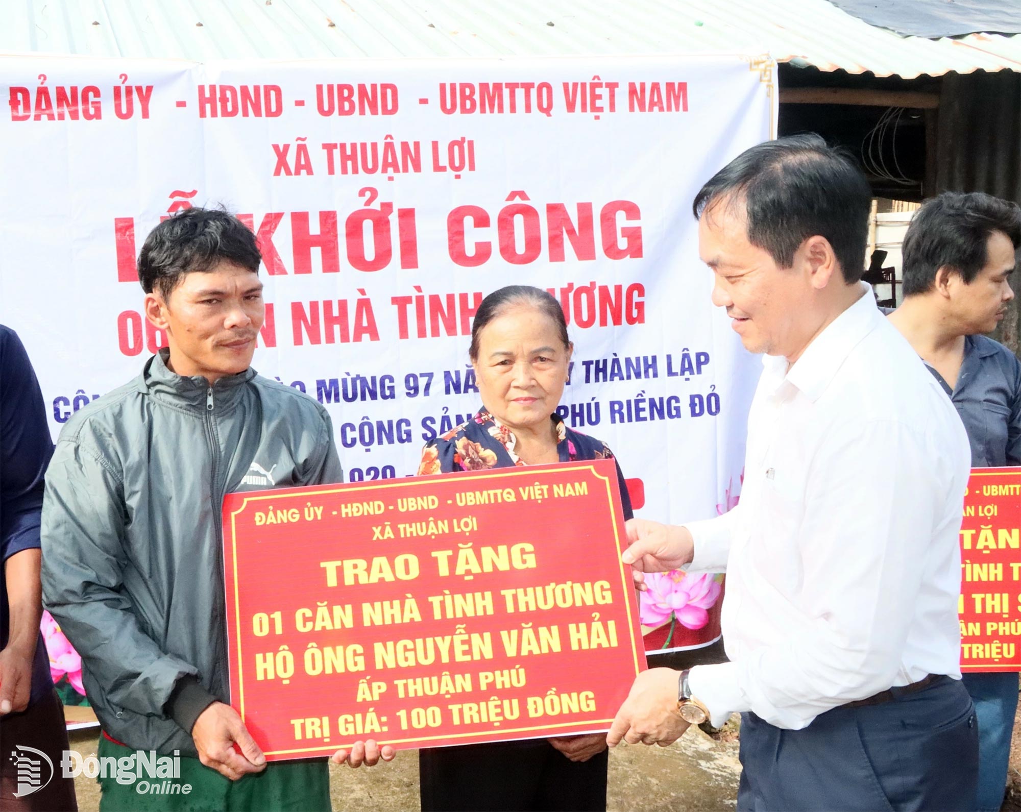 Chủ tịch UBND xã Thuận Lợi Nguyễn Đức Thành trao bảng tượng trưng tặng nhà tình thương cho hộ nghèo. Ảnh: Quang Minh