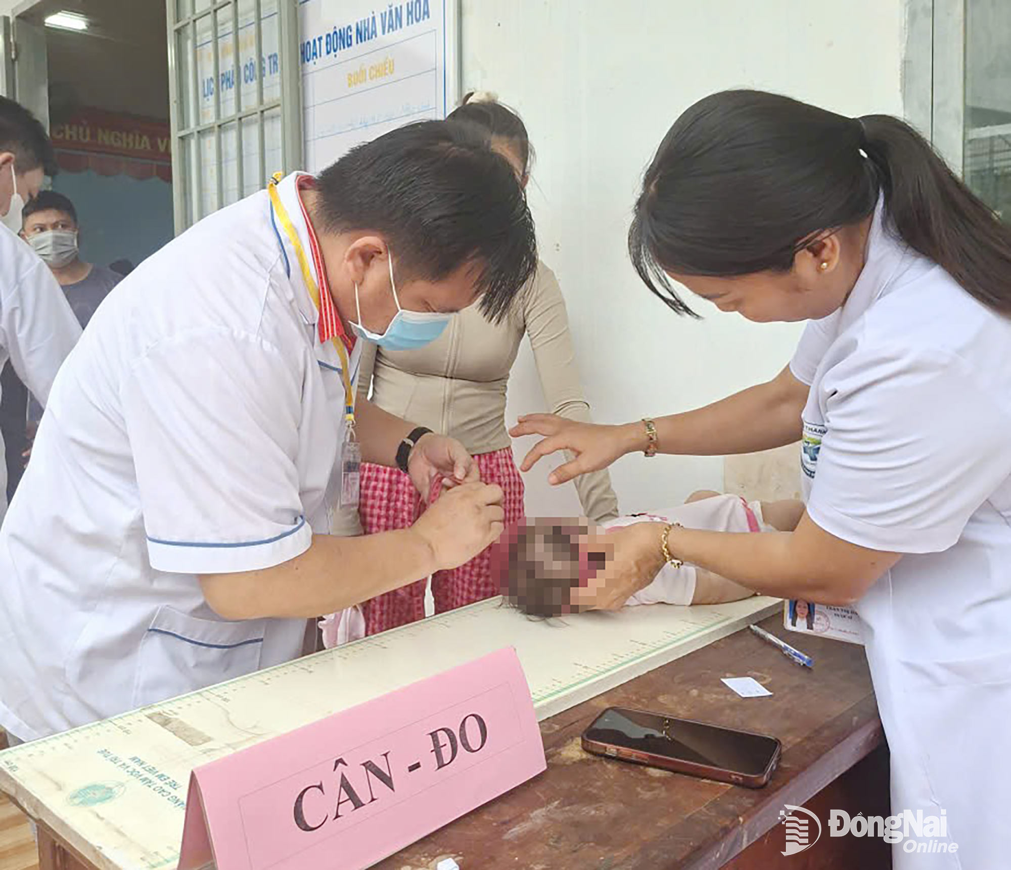 Nhân viên y tế đo chiều cao và cân nặng cho trẻ. Ảnh: CTV