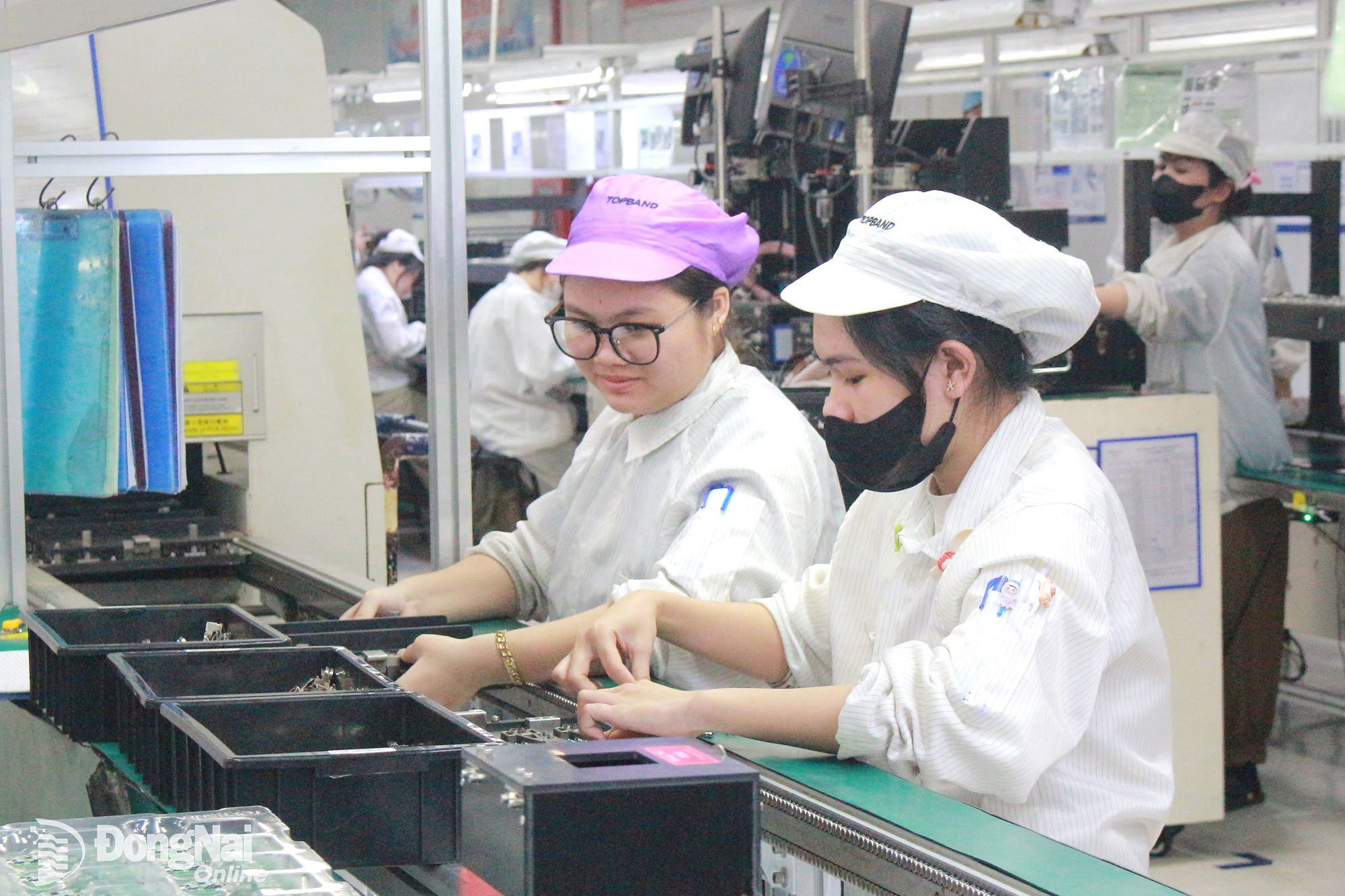 Công nhân Công ty TNHH Topband Smart Đồng Nai Việt Nam phấn khởi làm việc tại xưởng sản xuất trước thông tin tăng lương. Ảnh: Nguyễn Hòa
