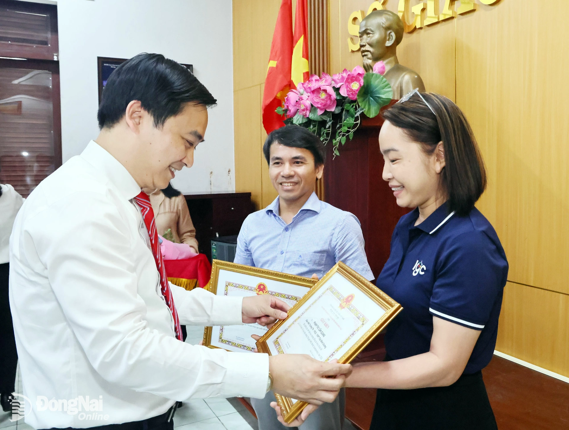 Dr. Dang Anh Tuan, Director of the Department of Education and Training, presents certificates of merit to two teachers who supported the students at international competitions. Photo: Cong Nghia

