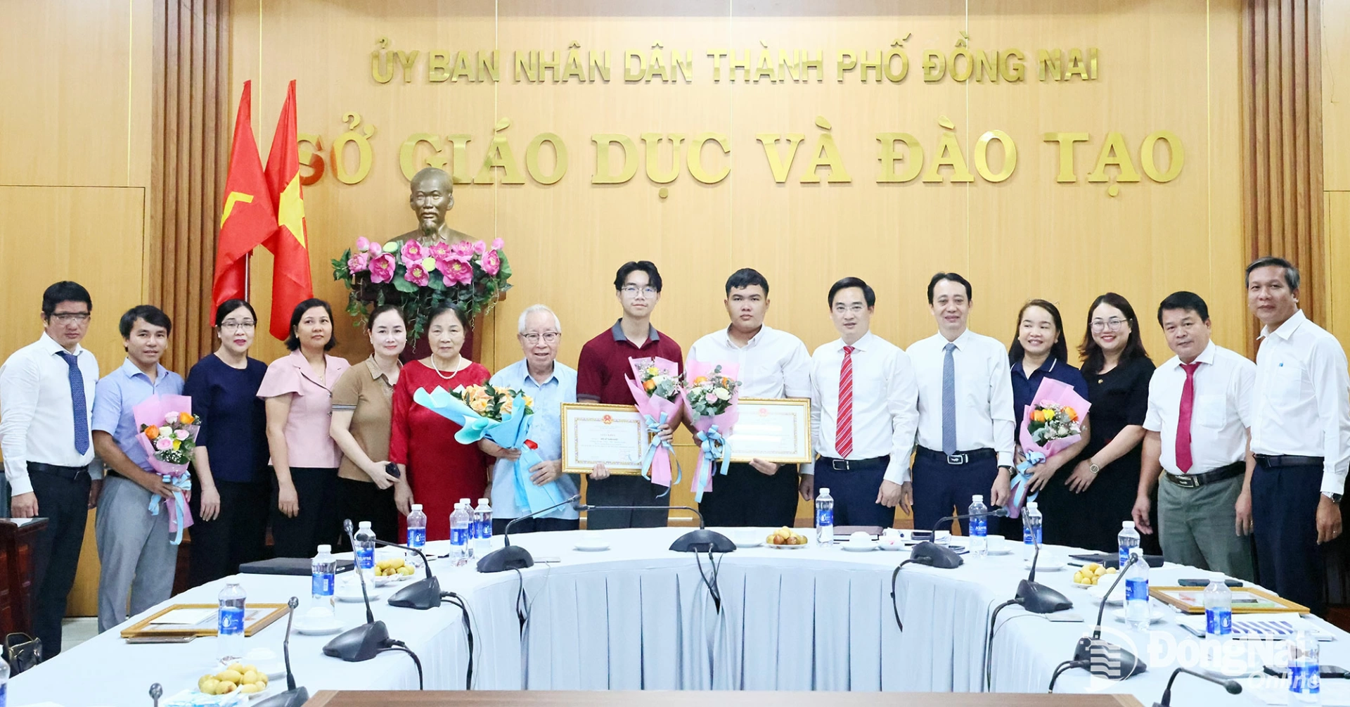 Leaders of the Dong Nai Department of Education and Training pose for a commemorative photo with the two honored students, their family members, and teachers who came to celebrate their achievements. Photo: Cong Nghia

