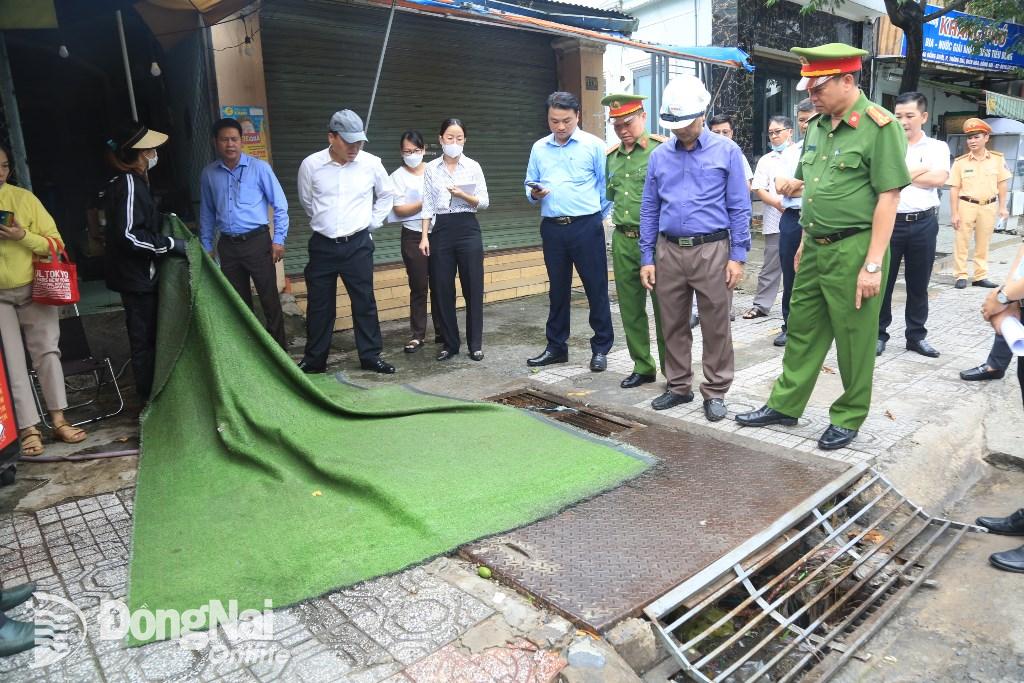 Một hộ kinh doanh trên đường Đồng Khởi dùng bạt nhựa phủ kín nắp hố ga thoát nước bị yêu cầu dọn dẹp