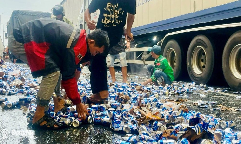 Người dân địa phương và tài xế hỗ trợ thu gom các thùng bia đổ ra hầm chui ngã tư Vũng Tàu. Ảnh: CTV