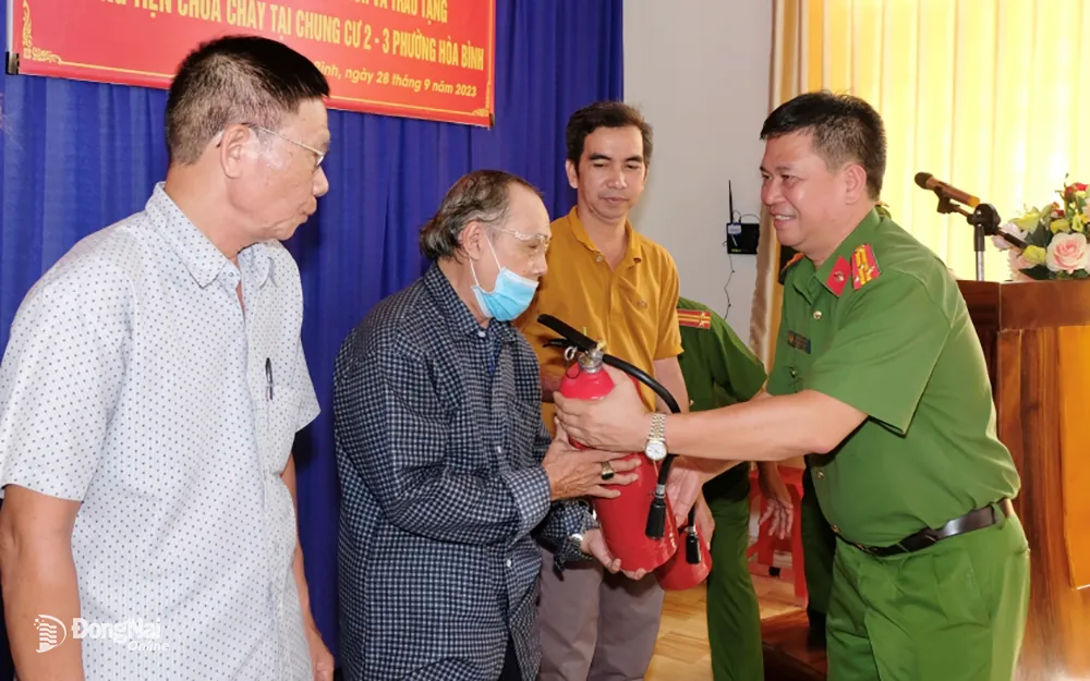 Công an TP.Biên Hòa trao tặng thang dây, mặt nạ phòng độc và bình chữa cháy cho người dân chung cư C23. Ảnh: Đăng Tùng