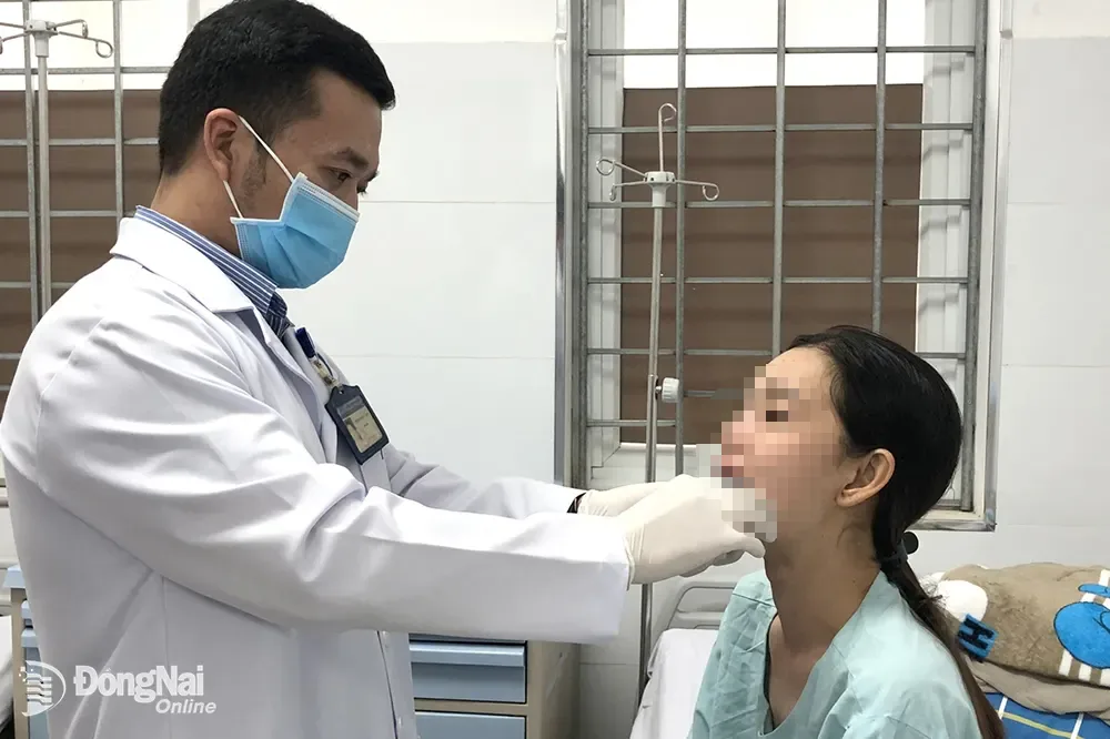 Bác sĩ kiểm tra vùng sàn miệng cho bệnh nhân sau ca phẫu thuật