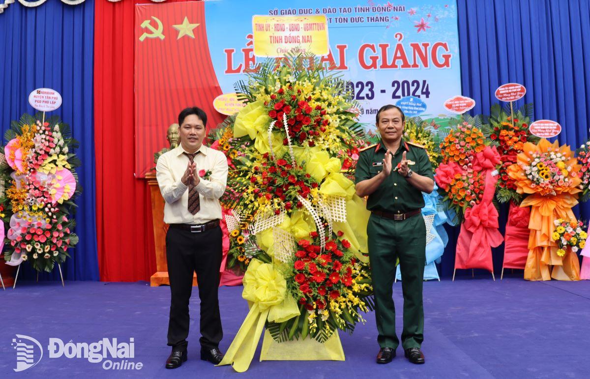 Đại tá Vũ Văn Điền tặng lẵng hoa của Tỉnh ủy, HĐND, UBND, Ủy ban MTTQ Việt Nam tỉnh cho nhà trường. Ảnh: Nguyệt Hà