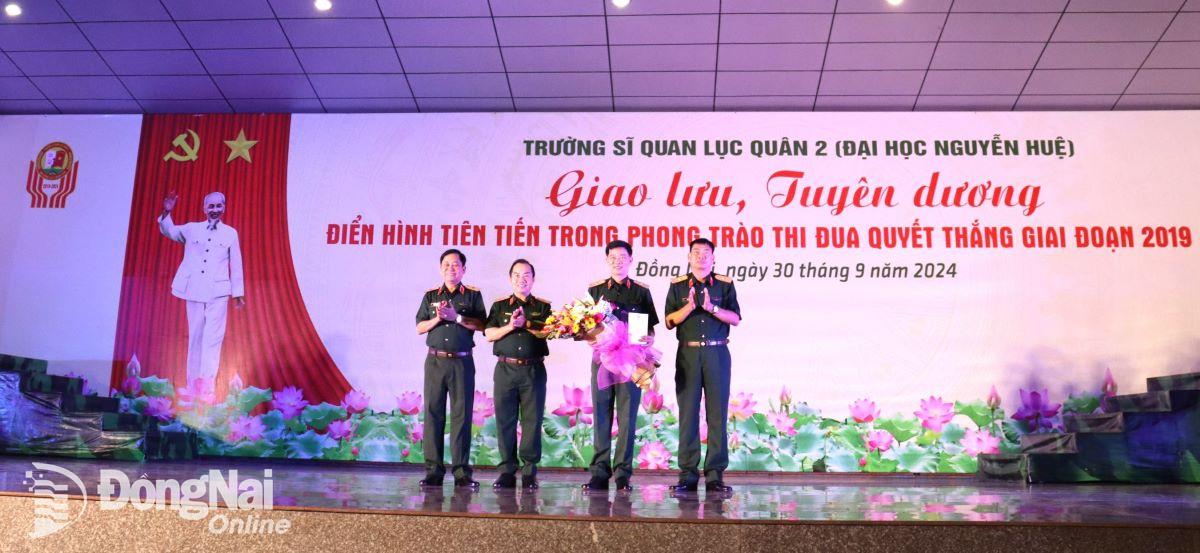 Thủ trưởng nhà trường tặng hoa chúc mừng thiếu tướng, PGS.TS, Nhà giáo nhân dân Vũ Thanh Hiệp tại lễ tuyên dương. Ảnh: Nguyệt Hà