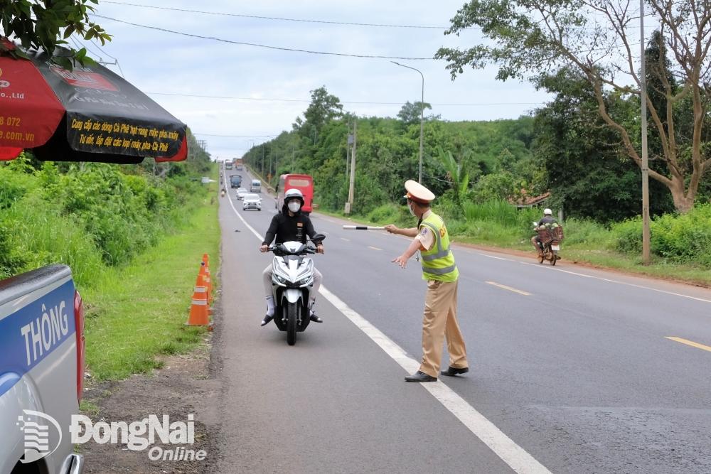 Lực lượng cảnh sát giao thông kiểm soát các phương tiện lưu thông trên quốc lộ 20 (huyện Định Quán). Ảnh: Đăng Tùng