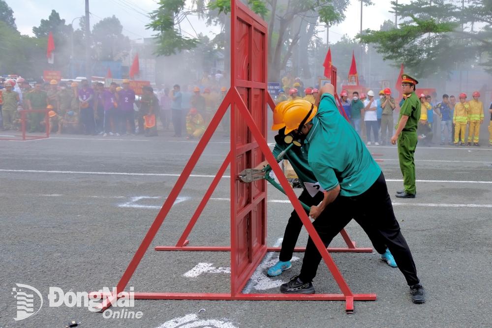 Điểm mới của nội dung kiểm tra “Đội hình tổng hợp 300m chữa cháy, cứu người, cứu tài sản” năm 2024 là đội thi phải kìm cộng lực để phá khóa trước khi vào cứu người. Ảnh: Minh Thành